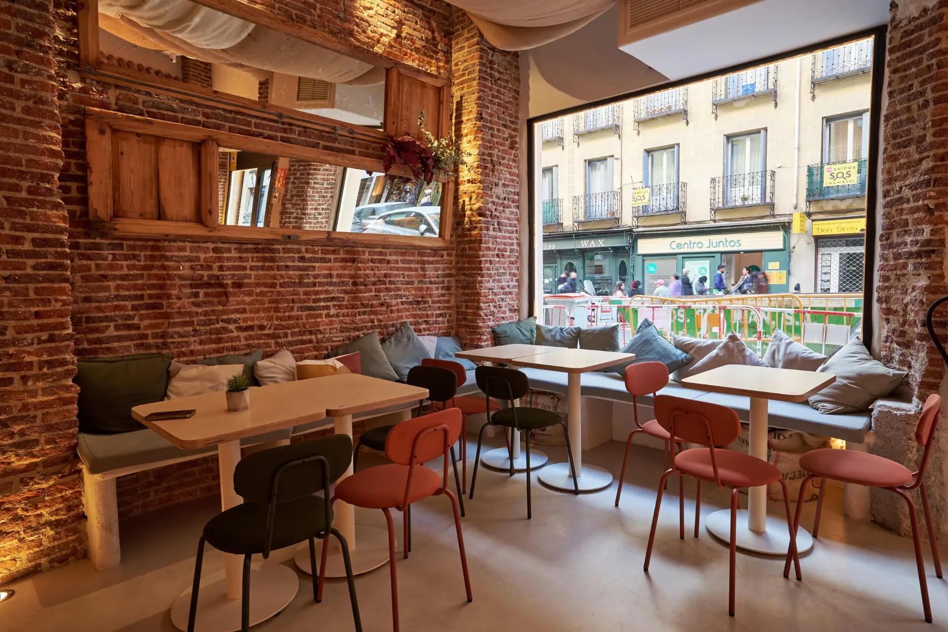 Sala de El Patio de La Tomata con ladrillo visto y gran ventanal a la calle Ponzano